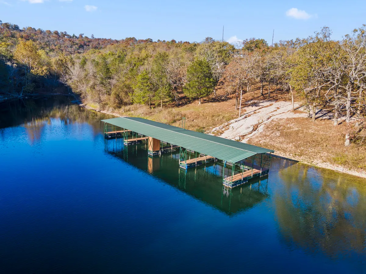 A tranquil dock extends over calm water, bordered by trees, evoking a peaceful lakeside retreat. The dock is ideal for boating, fishing, or relaxing by the water, with a soft, natural ambiance.